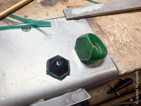 The ring is mostly sculpted, and a thin band of wax encircles the onyx.